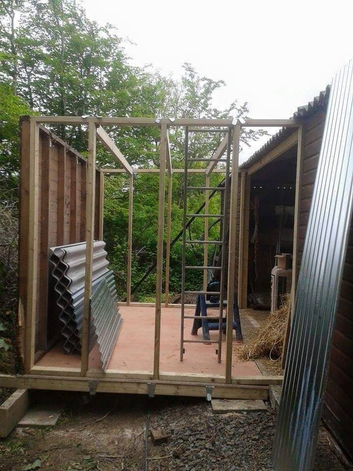 Bespoke workshop shed mid-build — timber frame up, corrugated panels ready for cladding